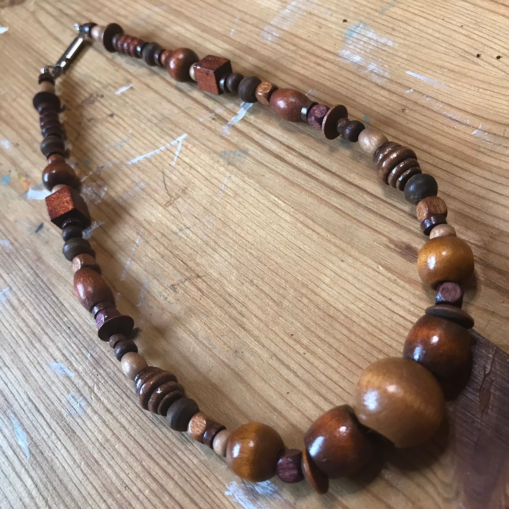 DARK WOOD BEAD SHORT NECKLACE LAYING ON WOOD TABLE