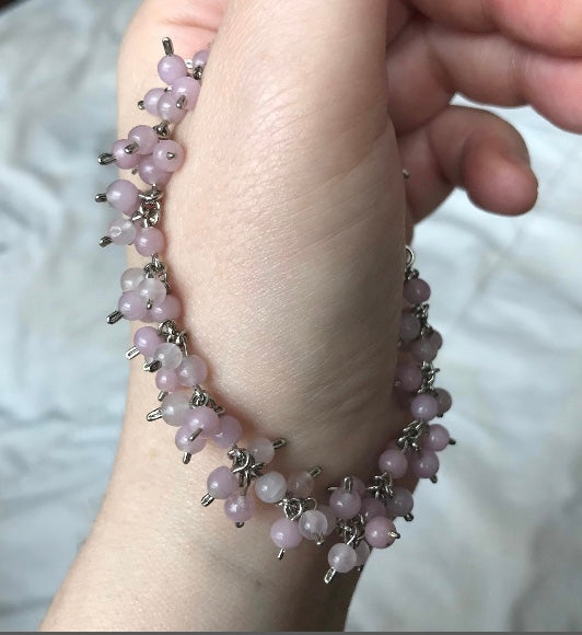 ROSE QUARTZ BEAD BRACELET HANGING OFF THE THUMB